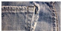 Frayed and torn jeans pocket before repair